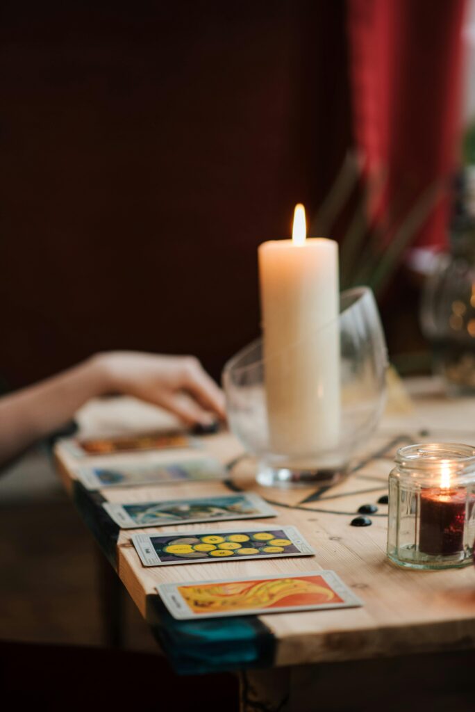 A mystical scene of tarot cards and candles on a wooden table, evoking a sense of enchantment.